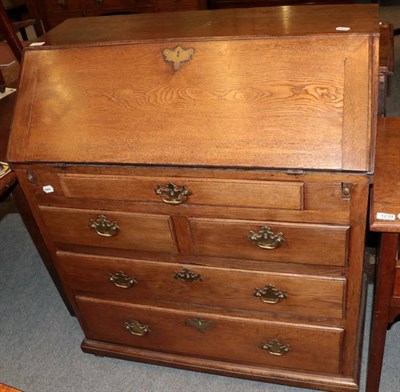 Lot 1230 - George III oak bureau with fall front and five drawers below