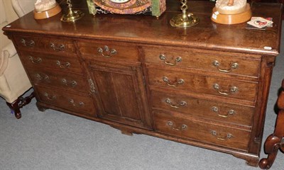 Lot 1315 - George III oak dresser base with nine drawers and a cupboard door