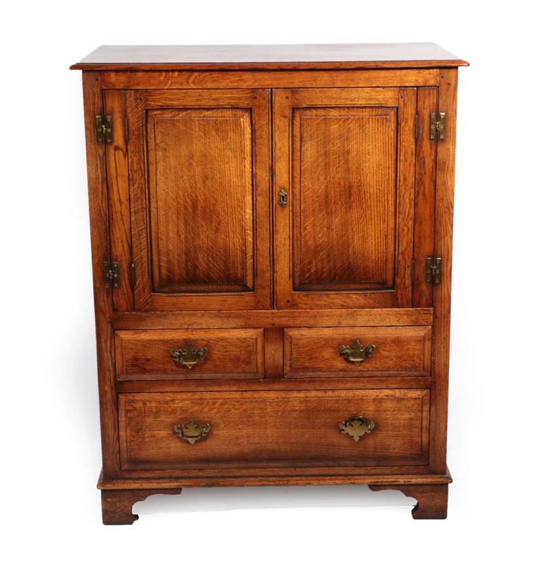 Lot 435 - A Reproduction Oak Cupboard, with moulded cupboard doors above two short and one long drawer,...