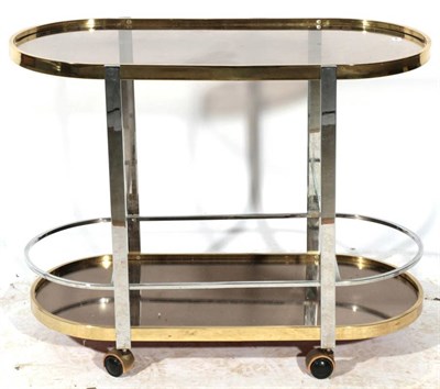Lot 521 - A 1970's Brass, Chromed Metal and Glass Three-Tier Trolley, of oval form, on tubular supports...