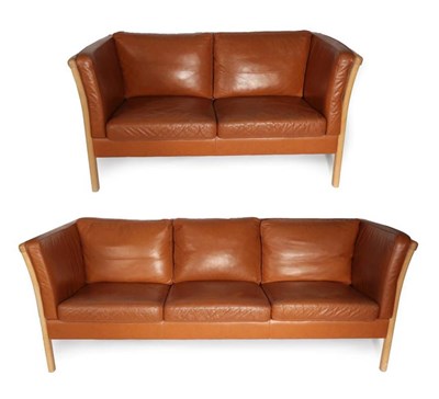 Lot 557 - A Pair of 1970's Danish Stouby Sofas, covered in tan leather, comprising a three-seater sofa,...