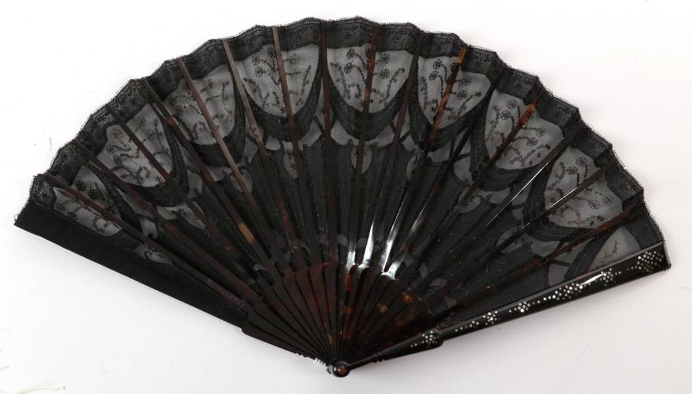 Lot 2100 - A Circa 1905 Tortoiseshell Fan, the monture piqué, the black gauze leaf decorated in swags...