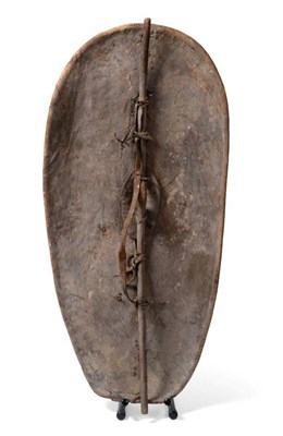 Lot 157 - A Masai Buffalo Hide Shield, Kenya, of convex oblong form, with unusual scarified and red...