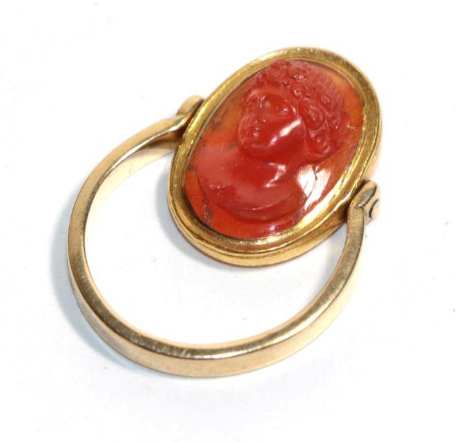 Lot 20 - A carved carnelian cameo mounted swivel ring, carved in high relief depicting the bust of...