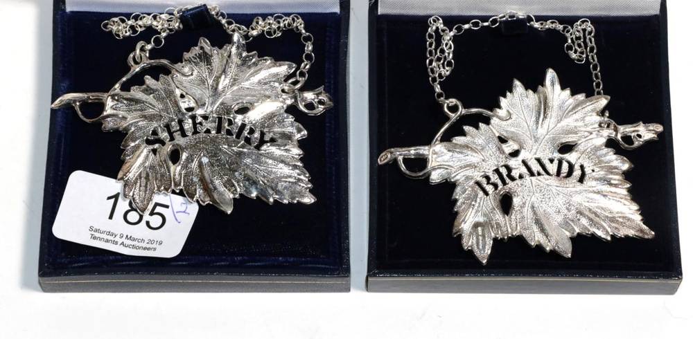 Lot 185 - A pair of modern cast silver decanter labels, Birmingham 2003/06, modelled as a vine leaf and...