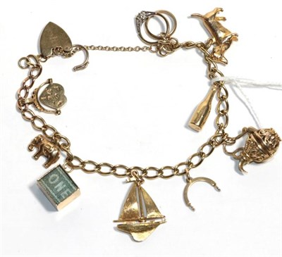Lot 206 - A charm bracelet, stamped '9' '.375', hung with nine charms including an elephant, a bottle of...