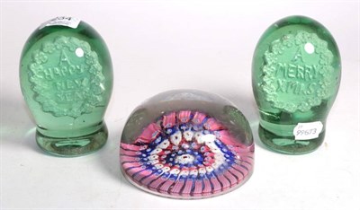 Lot 234 - A pair of sulfide dump weights, Happy Chistmas, Happy New Year; and a large Millefiore paper weight