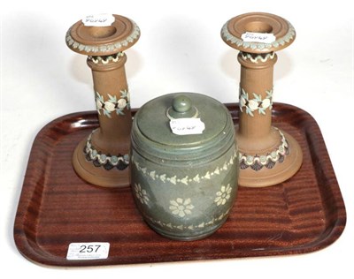 Lot 257 - A Royal Doulton stoneware tobacco jar and a pair of Royal Doulton candlesticks, decorated with...