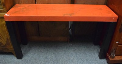 Lot 1188 - A modern red and black plastic console table