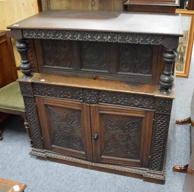 Lot 1197 - A Victorian carved oak cupboard, the hinged lid above two cupboard doors