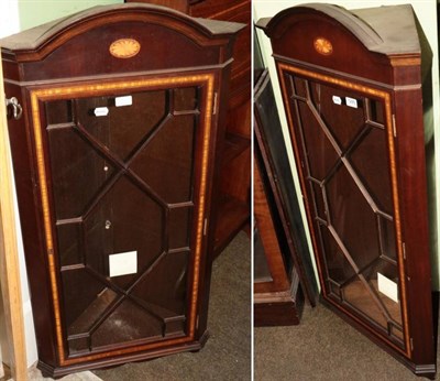 Lot 1285 - A pair of mahogany and satinwood banded hanging corner cupboards (modern)