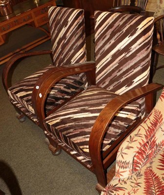 Lot 1347 - A pair of mid-20th century oak reclining armchairs, with curved arm rests and sledge bases