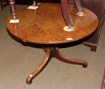 Lot 1359 - A late George III oak tilt top circular breakfast table