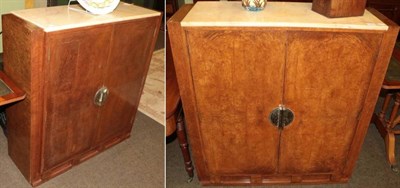 Lot 1384 - A pair of Art Deco marble top burr walnut cabinets