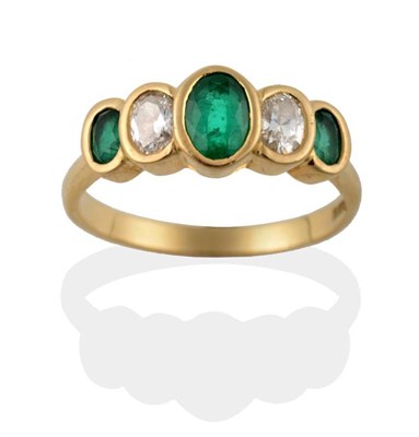Lot 111 - An 18 Carat Gold Emerald and Diamond Five Stone Ring, the graduated oval cut emeralds alternate...