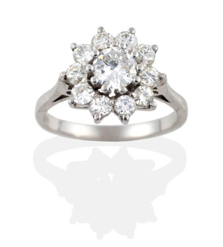 Lot 122 - A Diamond Cluster Ring, a round brilliant cut diamond within a border of ten smaller diamonds,...