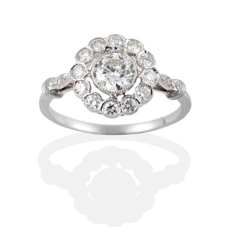 Lot 124 - An 18 Carat White Gold Diamond Cluster Ring, the round brilliant cut diamonds in millegrain...