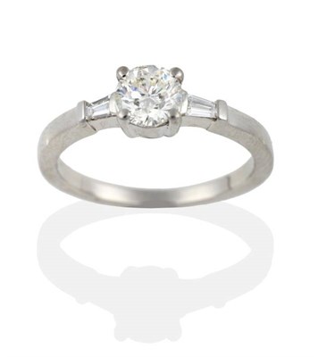 Lot 127 - A Platinum Diamond Ring, the round brilliant cut diamond within tapered baguette cut shoulders,...