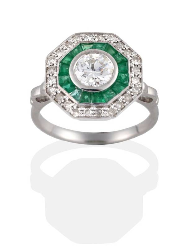Lot 148 - A Diamond and Emerald Cluster Ring, an old cut diamond within a border of calibré cut emeralds, to