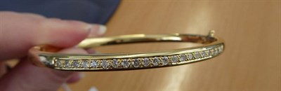 Lot 157 - An 18 Carat Gold Diamond Bangle, half hinged and set with round brilliant cut diamonds to one half