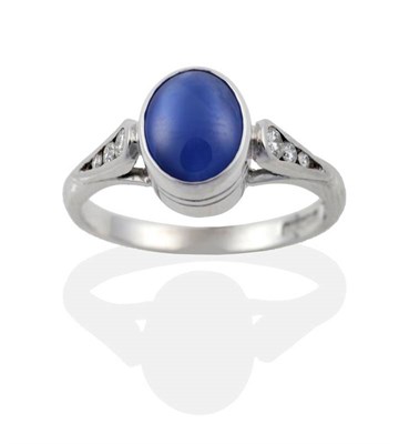Lot 178 - An 18 Carat White Gold Star Sapphire and Diamond Ring, the oval cabochon star sapphire in a...