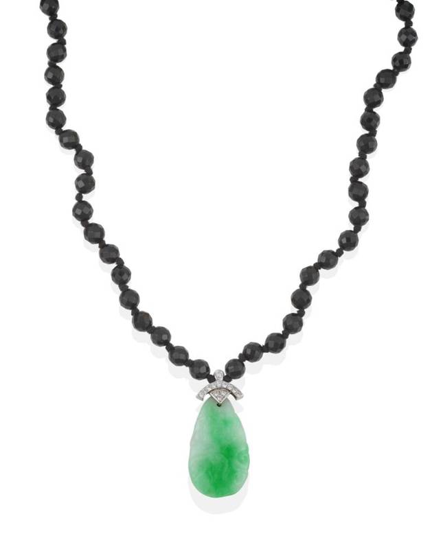 Lot 185 - A Jade and Diamond Pendant on a Bead Necklace, the jade drop carved with a fish hangs on an 18...