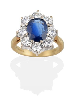Lot 190 - An 18 Carat Gold Sapphire and Diamond Cluster Ring, the oval mixed cut sapphire within a border...