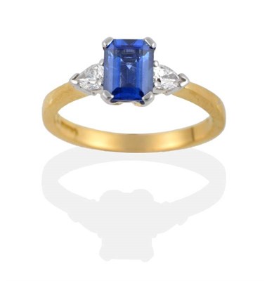 Lot 193 - An 18 Carat Gold Sapphire and Diamond Three Stone Ring, the emerald-cut sapphire flanked by two...