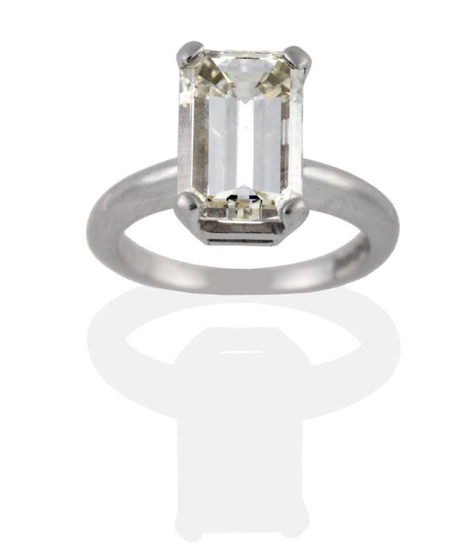 Lot 198 - A Platinum Diamond Solitaire Ring, the emerald-cut diamond in a four claw setting to a rounded...