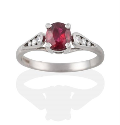 Lot 201 - An 18 Carat White Gold Ruby and Diamond Ring, the cushion shaped ruby in a claw setting to...