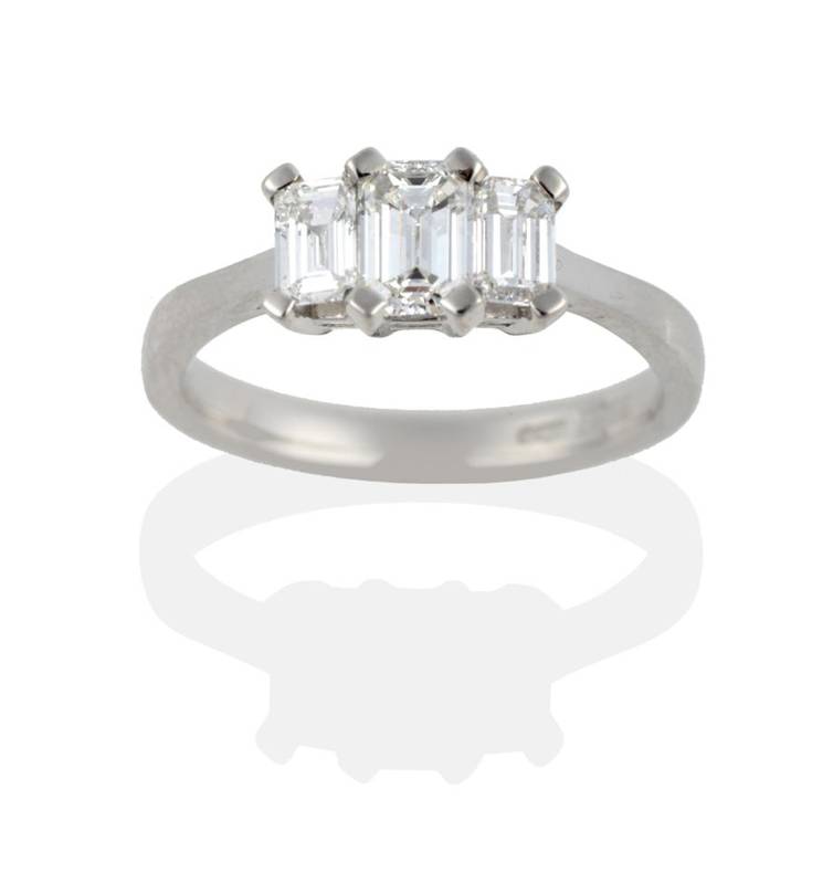Lot 217 - A Platinum Diamond Three Stone Ring, the emerald-cut diamonds in claw settings on a tapered...