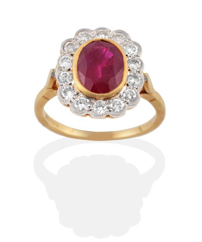 Lot 231 - An 18 Carat Gold Ruby and Diamond Cluster Ring, the oval mixed cut ruby in a yellow rubbed over...