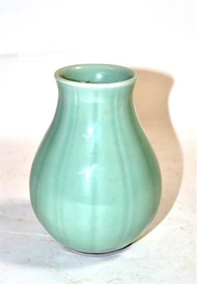 Lot 555 - A Chinese Pale Celadon Glazed Porcelain Vase, Qing Dynasty, of fluted baluster form with...