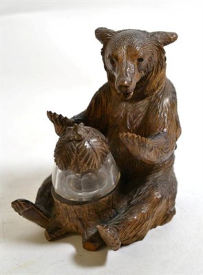 Lot 580 - ~ A Black Forest Carved Wood Inkwell, late 19th century, modelled as a seated bear holding a...