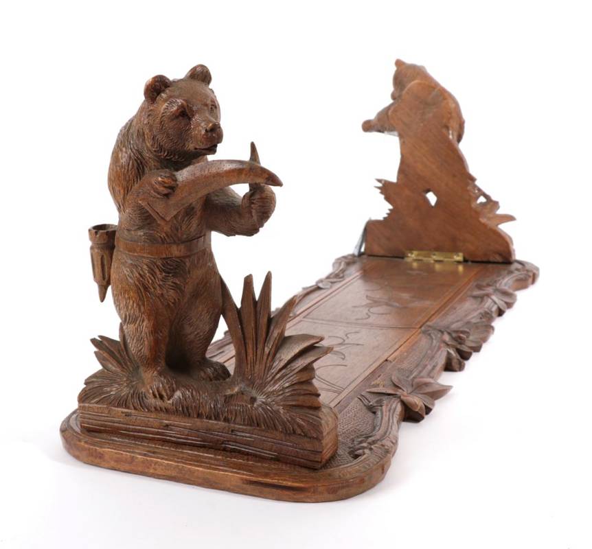 Lot 581 - ~ A Black Forest Carved Wood Book Trough, late 19th century, with bear bookends, 53cm wide