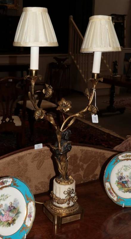 Lot 597 - ~ A French Gilt and Patinated Bronze Candelabra, late 19th century, as cherubs holding...