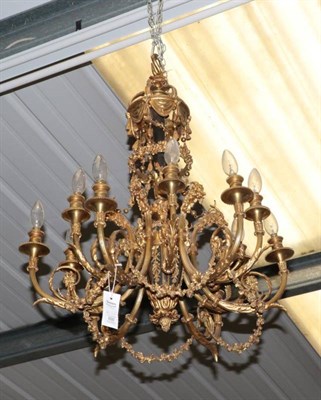 Lot 600 - A Gilt Metal Twelve-Light Chandelier, in Louis XVI style, with scroll cresting over foliate...