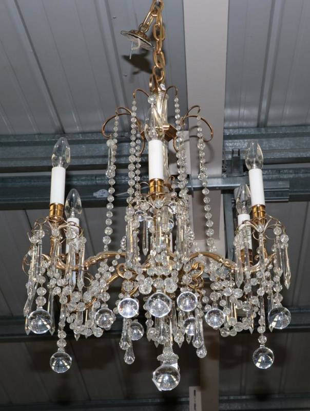 Lot 602 - ~ A Gilt Metal and Cut Glass Six-Light Chandelier, the scroll branches hung with facetted...