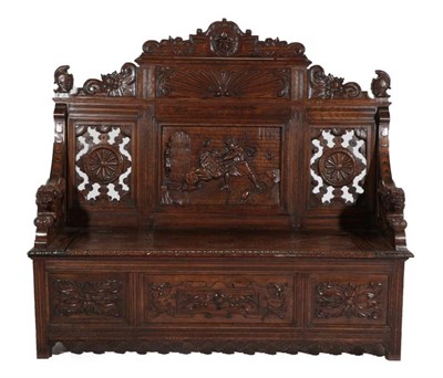 Lot 668 - A Carved Oak Box Settle, late 19th/early 20th century, the carved top rail flanked by finials...