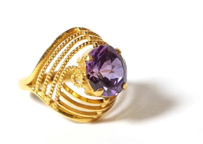 Lot 54 - An amethyst ring, an oval mixed cut amethyst within a plain bar and beaded frame, finger size K