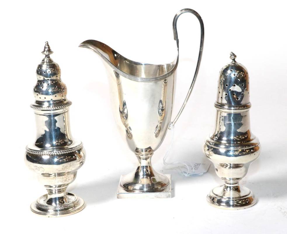 Lot 198 - A George III style pedestal cream jug, C J Vander, London 1976; and two Edwardian silver casters of