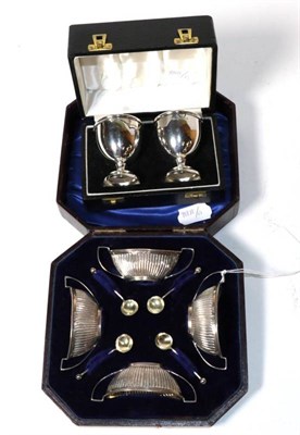 Lot 216 - A set of four Edwardian silver twin handled salts and spoons, Birmingham 1901, in a fitted...