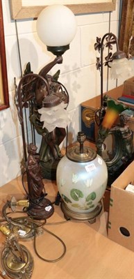Lot 1083 - A group of decorative patinated resin figural table lamps; a glass ovoid table lamp; and a pair...