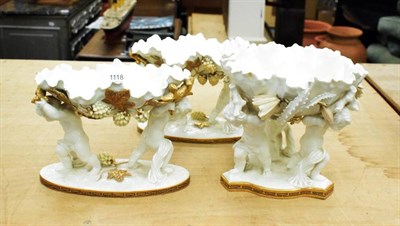 Lot 1118 - A Moore glazed three piece garniture, circa 1880, modelled as shells supported by putti on...