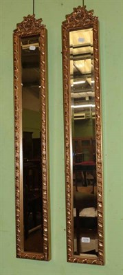 Lot 1276 - Pair of modern gilt framed bevel glass mirrors of narrow form, 120cm by 18cm