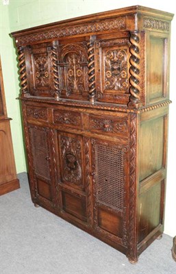 Lot 1280 - A reproduction oak carved court cupboard