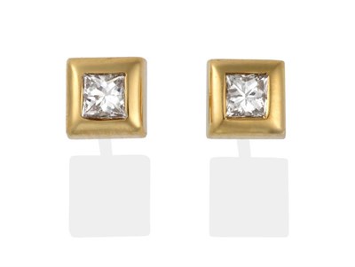 Lot 2002 - A Pair of 18 Carat Gold Princess Cut Diamond Solitaire Earrings, in broad rubbed over settings,...