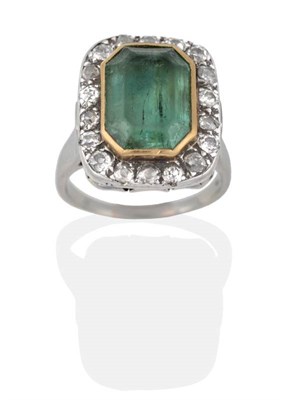 Lot 2027 - An Emerald and Diamond Ring, an octagonal cut emerald in a closed backed grain setting and within a