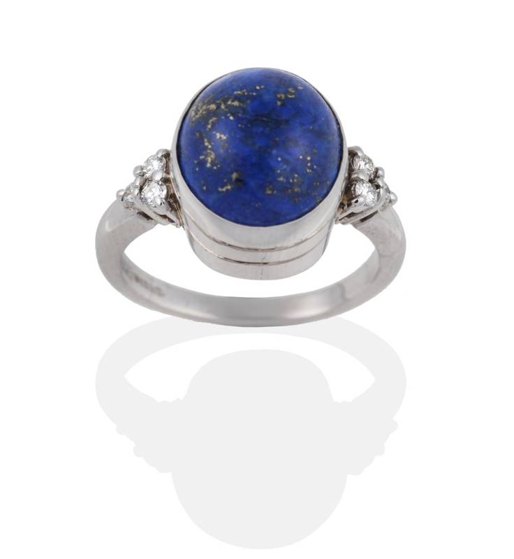 Lot 2031 - An 18 Carat White Gold Lapis Lazuli and Diamond Ring, the oval cabochon lapis lazuli in a...