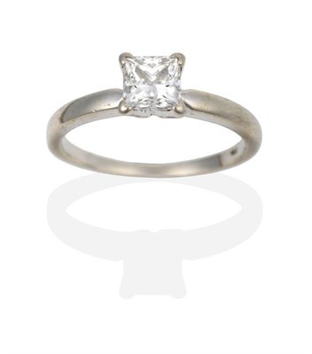 Lot 2033 - A Diamond Solitaire Ring, the princess cut diamond in a white claw setting, to a tapered...